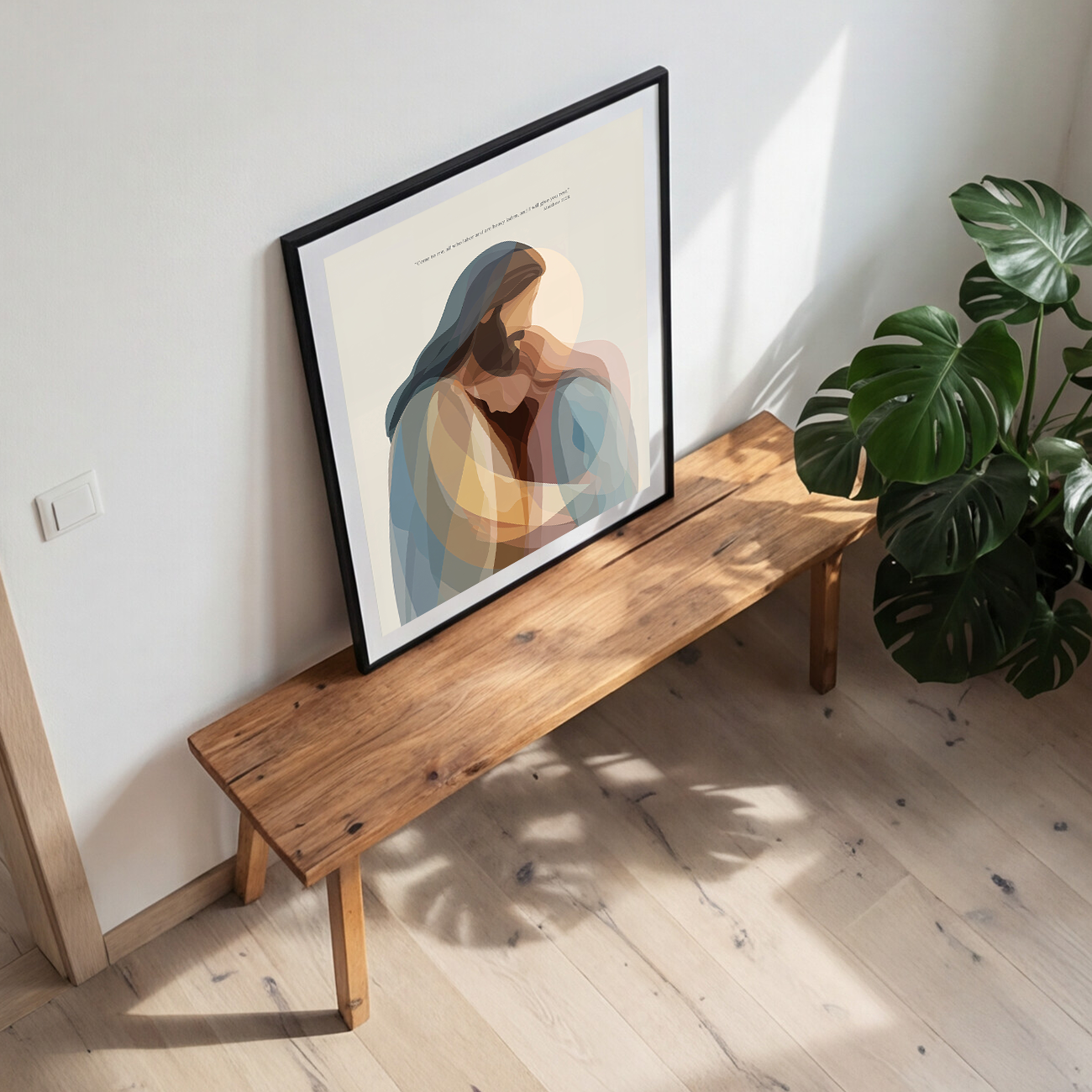 Wooden bench with a framed artwork leaning against a white wall, next to a potted plant.