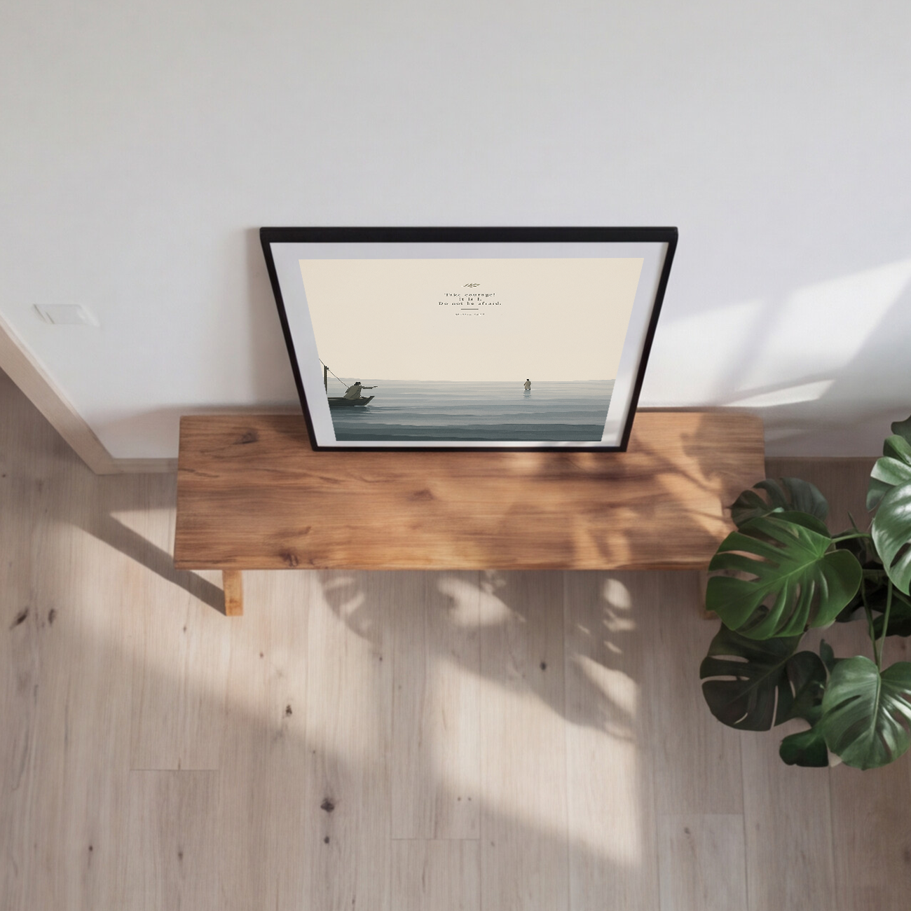 Framed artwork of two figures on a boat and in the water with a quote.