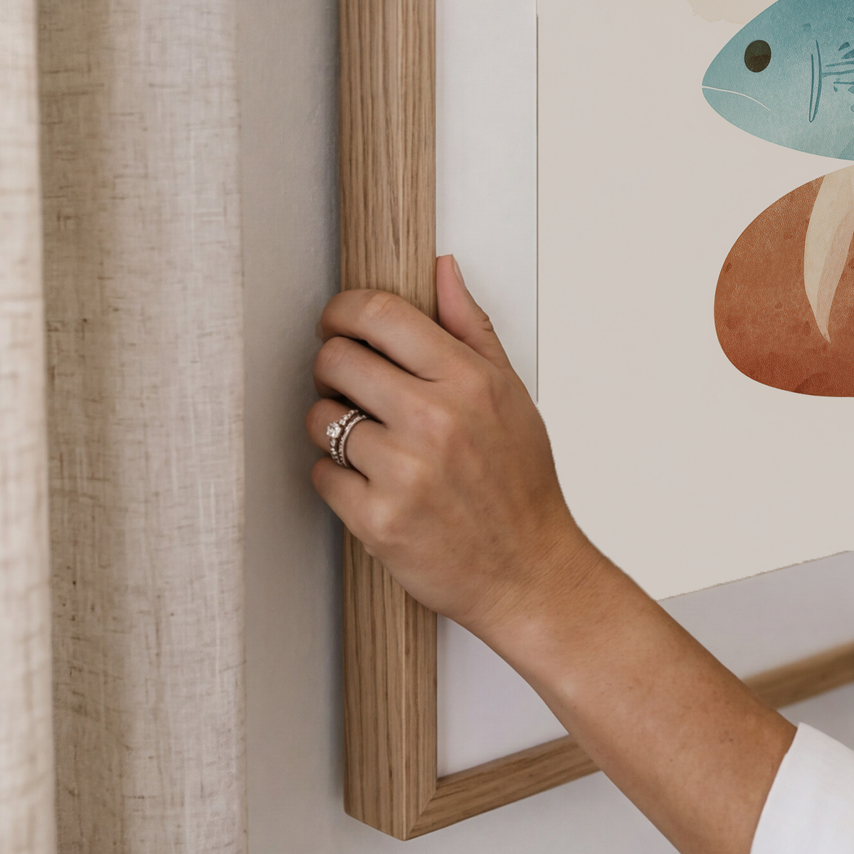 Framed artwork of bread and fish shapes on a beige wall