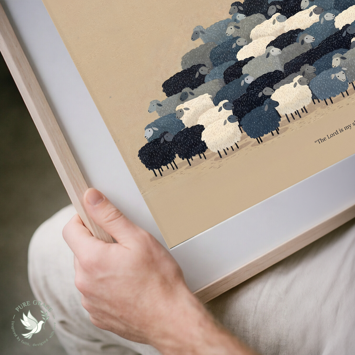 Framed artwork of sheep on a beige background, held by a hand.