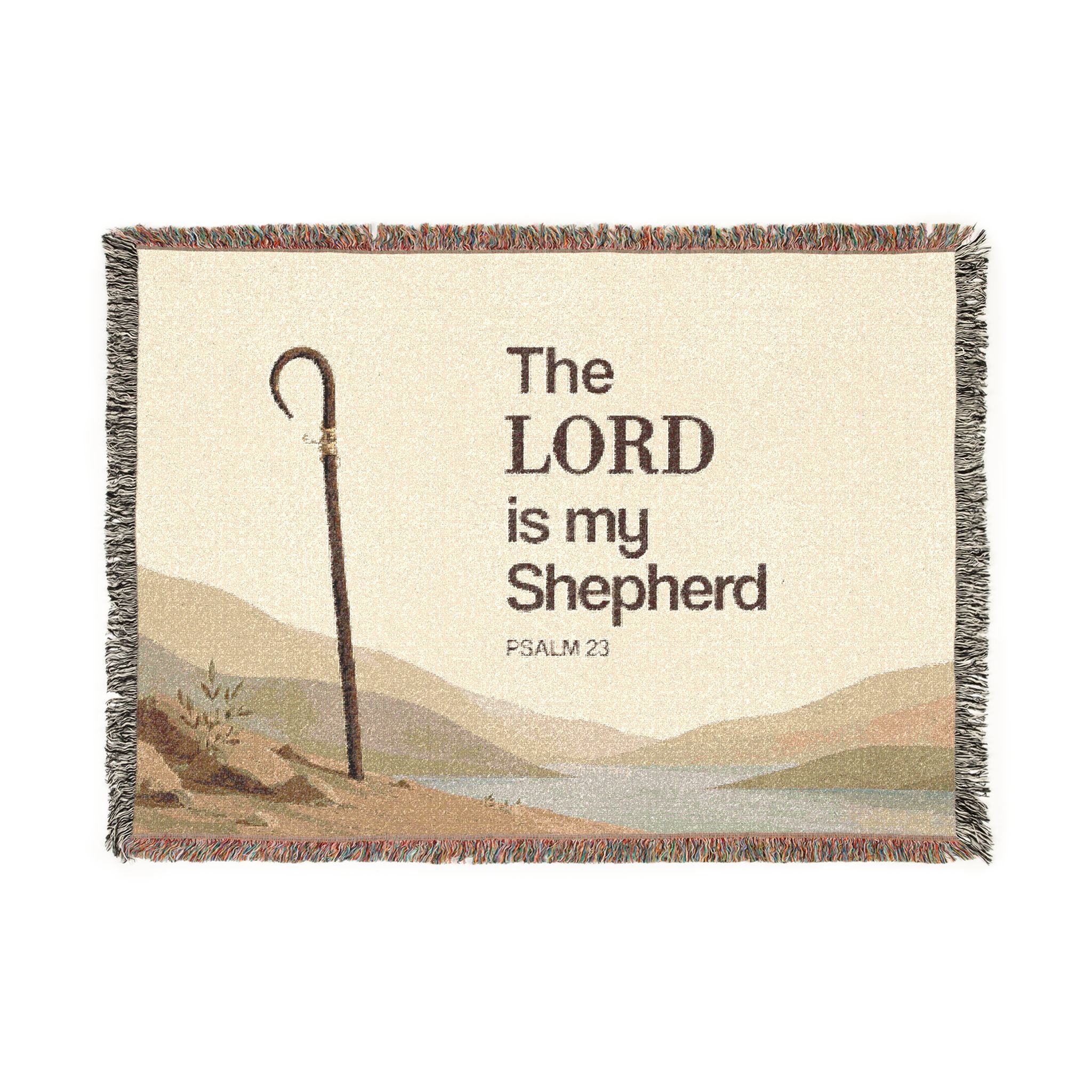 A rectangular woven throw blanket with fringe edges, featuring the text 'The LORD is my Shepherd PSALM 23' over a scenic landscape illustration with a shepherd's staff, on a white background.
